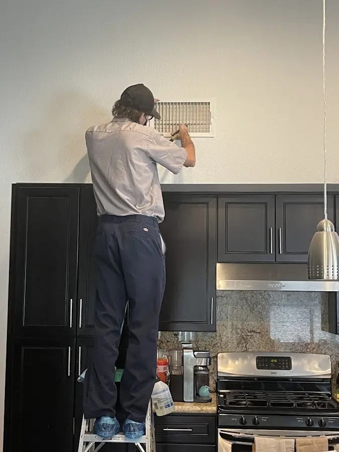 Technician inspecting an air vent during HVAC service in Casa de Oro-Mount Helix